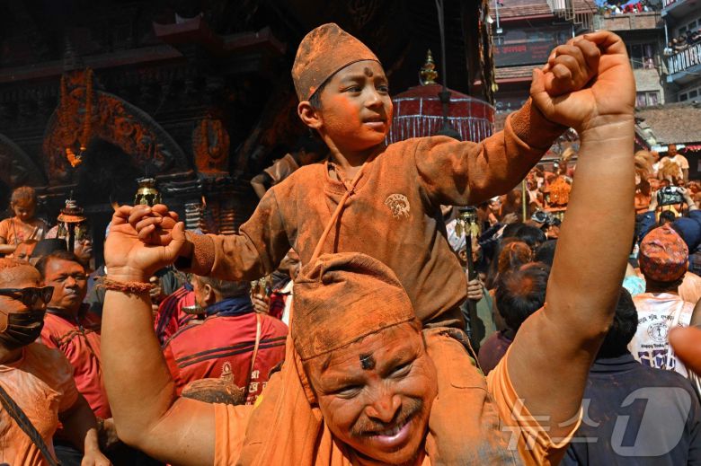 15일(현지시간) 네팔 카트만두에서 열린 신두르 자트라 축제에서 시민들이 주홍 가루를 뿌리며 축제를 즐기고 있다.  ⓒ AFP=뉴스1