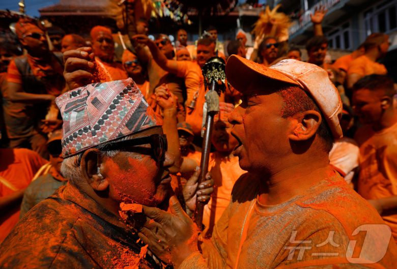 15일(현지시간) 네팔 박타푸르에서 열린 신두르 자트라 축제에서 시민들이 주홍 가루를 뿌리며 축제를 즐기고 있다. ⓒ 로이터=뉴스1