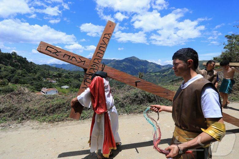 18일(현지시간) 콜롬비아 안티오키아주 엘 레티로에서 열린 성금요일 행사에서 십자가를 든 예수 행렬이 이동하고 있다. ⓒ AFP=뉴스1