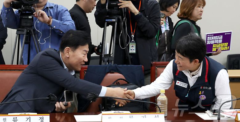 류기정 최저임금위원회 사용자위원과 이미선 근로자위원이 22일 오후 세종시 어진동 정부세종청사 고용노동부에서 열린 2026년 최저임금위원회 제1차 전원회의에 참석하며 악수를 나누고 있다. 2025.4.22/뉴스1 ⓒ News1 김기남 기자