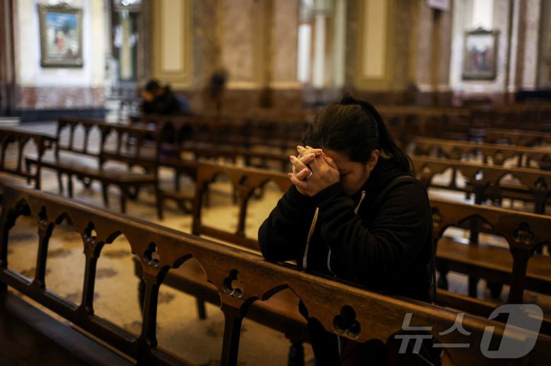 프란치스코 교황이 선종한 21일(현지시간) 아르헨티나 부에노스아이레스에서 바티칸이 프란치스코 교황의 서거를 발표한 후 한 시민이 교회 안에서 기도하고 있다. ⓒ 로이터=뉴스1 ⓒ News1 김성진 기자