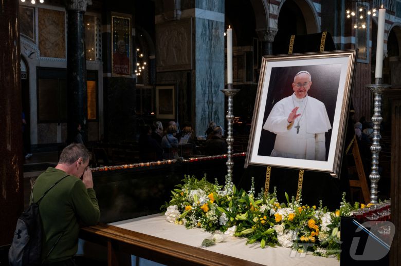 프란치스코 교황이 선종한 21일(현지시간) 메트로폴리탄 대성당에서 한 시민이 프란치스코 교황의 초상화 앞에서 기도하고 있다. ⓒ 로이터=뉴스1 ⓒ News1 김성진 기자