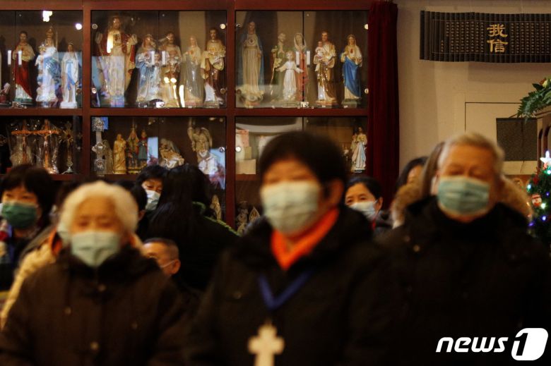 마스크를 쓴 예배자들이 2021년 12월 24일 중국 베이징 왕푸징 거리에 있는 요셉 교회에서 크리스마스 이브 미사에 참석하고 있다. ⓒ 로이터=뉴스1 ⓒ News1 김지현 기자