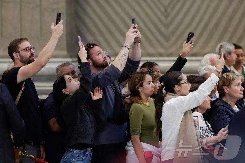 23일(현지시간) 프란치스코 교황의 관이 안치된 바티칸 성 베드로 대성당에서 신자들이 관을 촬영하고 있다. 2025.4.23 ⓒ 로이터=뉴스1