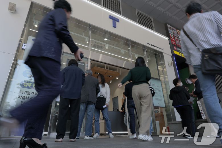 해킹 공격으로 가입자 유심 정보가 탈취된 SK텔레콤이 가입자 유심 무상 교체를 시작한 28일 오전 서울 종로구 T월드 매장 앞에서 고객들이 온라인 예약을 안내 받고 있다. 2025.4.28/뉴스1 ⓒ News1 박정호 기자