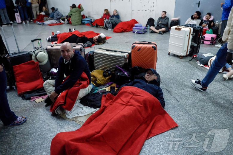이베리아 반도에 대규모 정전이 발생한 28일(현지시간) 스페인 마드리드 아토차 기차역 대합실에서 시민들이 누워 있다. 이날 정전으로 열차 운행이 중단됐다. ⓒ AFP=뉴스1