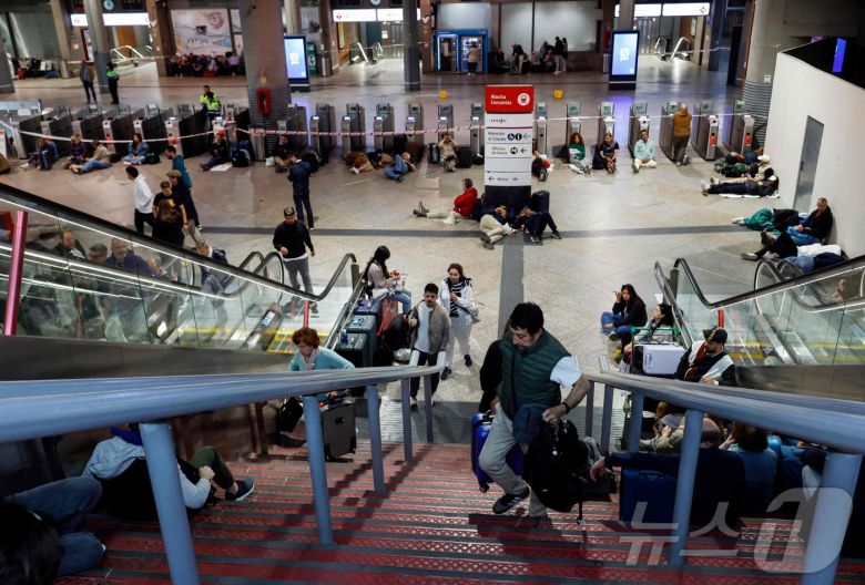 이베리아 반도에 대규모 정전이 발생한 28일(현지시간) 스페인 마드리드 아토차 기차역 대합실에서 시민들이 밤을 보낼 준비를 하고 있다. ⓒ AFP=뉴스1