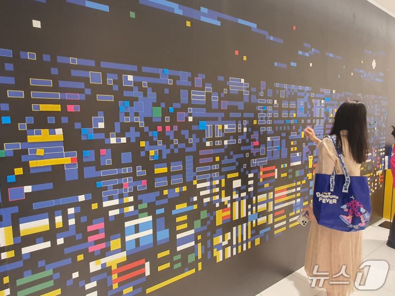 30일 서울 소공동 롯데백화점 에비뉴엘에서 한 고객이 주재범 작가의 고객 참여형 픽셀 아트를 체험하고 있다.