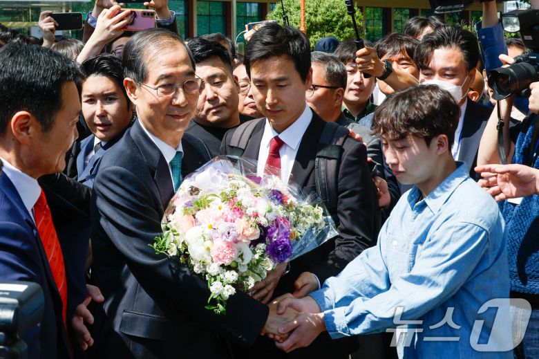 한덕수 전 국무총리가 2일 오전 서울 여의도 국회 소통관에서 '국민께 드리는 약속'을 주제로 제21대 대통령 선거 출마를 선언한 뒤 지지자로부터 꽃바구니를 받고 있다. 2025.5.2/뉴스1 ⓒ News1 안은나 기자
