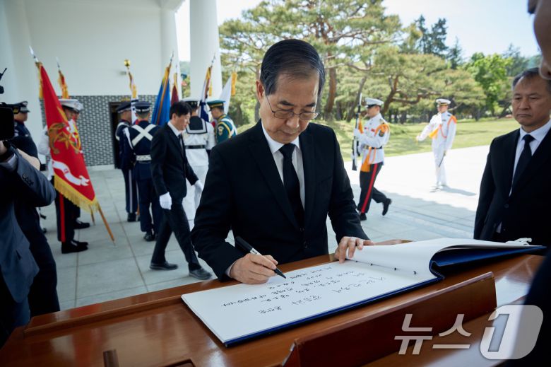 대선 출마를 선언한 한덕수 전 국무총리가 2일 서울 동작구 국립서울현충원 참배 후 방명록을 작성하고 있다. '대한민국이 갈등과 혼란을 넘어 앞으로, 오직 앞으로 나아갈 수 있도록 전력을 다하겠다'고 적었다. (한덕수 캠프 제공, 재판매 및 DB 금지) 2025.5.2/뉴스1