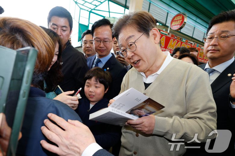 이재명 더불어민주당 대통령 후보가 골목골목 경청투어 이틀차를 맞은 6일 오전 충북 증평군 장뜰시장을 찾아 지지자에게 사인해주고 있다. 2025.5.6/뉴스1 ⓒ News1 안은나 기자