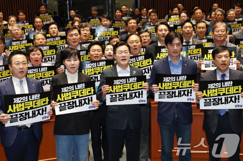 박찬대 더불어민주당 대표 직무대행 겸 원내대표와 의원들이 4일 오후 서울 여의도 국회에서 열린 긴급 의원총회에서 대법원을 규탄하는 구호를 외치고 있다. 2025.5.4/뉴스1 ⓒ News1 이광호 기자