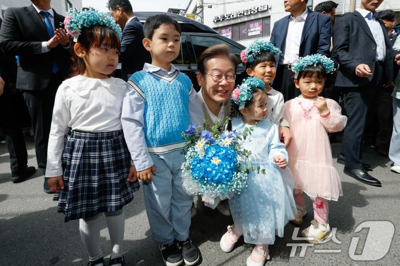 이재명 더불어민주당 대통령 후보가 6일 오전 골목골목 경청투어를 위해 충북 증평군 장뜰시장에 도착, 어린이들과 기념 촬영하고 있다. 2025.5.6/뉴스1 ⓒ News1 안은나 기자