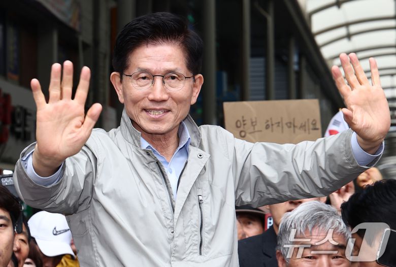 김문수 국민의힘 대통령 후보가 6일 경북 포항시 죽도시장에서 시민들을 향해 인사하고 있다. 뒷편에는 한 지지자가 '양보 하지 마세요'라고 적힌 종이를 들어보이고 있다. 2025.5.6/뉴스1 ⓒ News1 김민지 기자