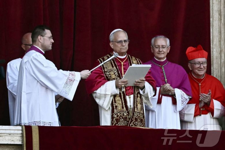 제267대 교황으로 선출된 로버트 프리보스트 미국 추기경(가운데)이 바티카 성베드로 대성당 발코니에서 첫 연설을 하고 있다. ⓒ AFP=뉴스1
