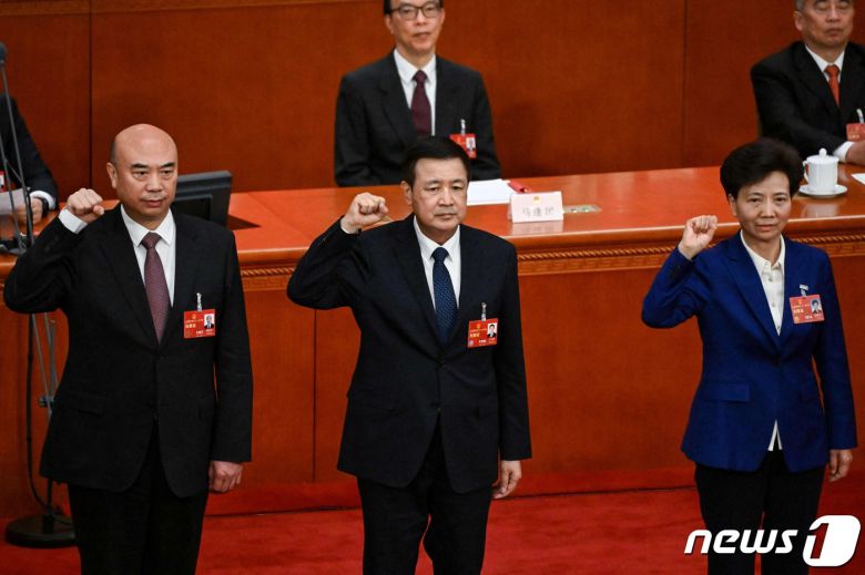 중국의 신임 부총리에 선출된 류궈중(왼쪽)과 각각 국무위원에 오른 왕샤오훙 공안부장(가운데), 션이친 당중앙위원이 선서를 하고 있다. 중국의 국회 격인 전국인민대표회의(전인대)는 12일 5차 전체 회의를 열어 국무원 부총리, 국가임원, 각료들의 인사를 결정했다. ⓒ AFP=뉴스1 ⓒ News1 최종일 기자