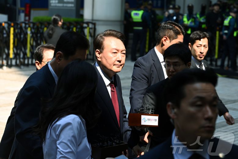 윤석열 전 대통령이 12일 오전 서울 서초구 중앙지방법원에서 열린 내란 우두머리 혐의, 직권남용 권리행사방해 혐의 사건 3차 공판에 출석, 취재진의 질문을 받으며 이동하고 있다. 2025.5.12/뉴스1 ⓒ News1 사진공동취재단