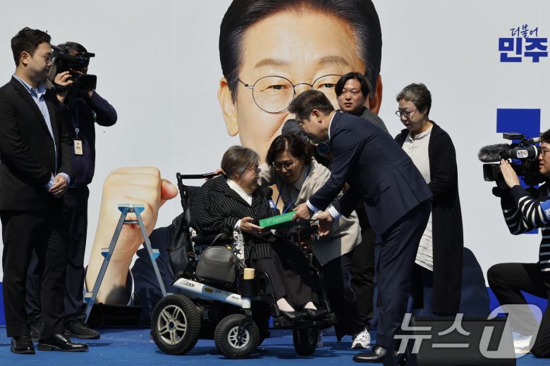 이재명 더불어민주당 대통령 후보가 12일 오전 서울 중구 청계광장에서 '빛의 혁명' 광화문 유세 시작을 알리며 박김영희 씨에게 녹서를 전달 받고 있다. 2025.5.12/뉴스1 ⓒ News1 안은나 기자