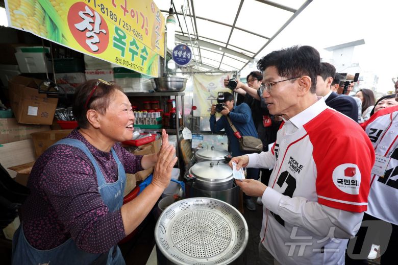 김문수 국민의힘 대통령 후보가 16일 경기도 수원시 팔달구 지동시장에서 열린 유세에서 상인과 만나 지지를 호소하고 있다. (공동취재) 2025.5.16/뉴스1 ⓒ News1 이광호 기자