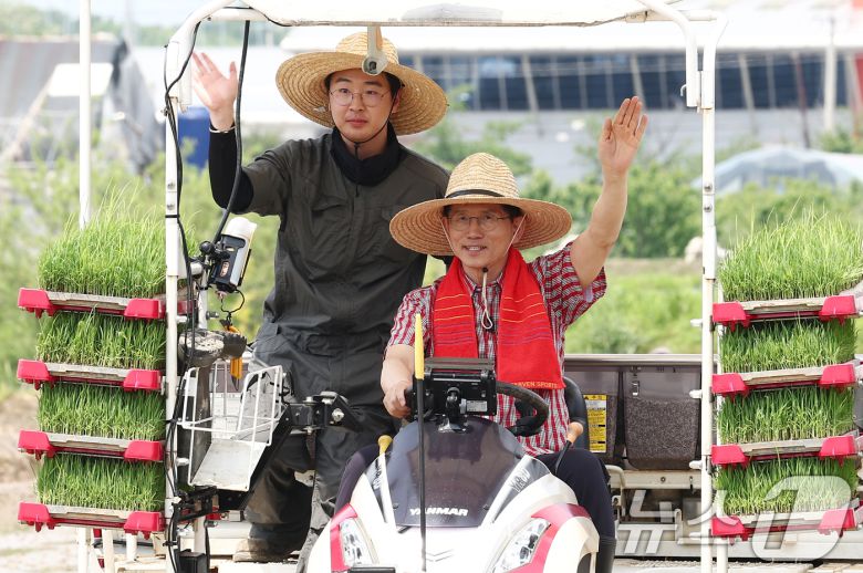 김문수 국민의힘 대통령 후보가 21일 경기 고양시 한 논에서 청년 농업인과 이앙기를 타고 손을 흔들고 있다. 2025.5.21/뉴스1 ⓒ News1 김민지 기자