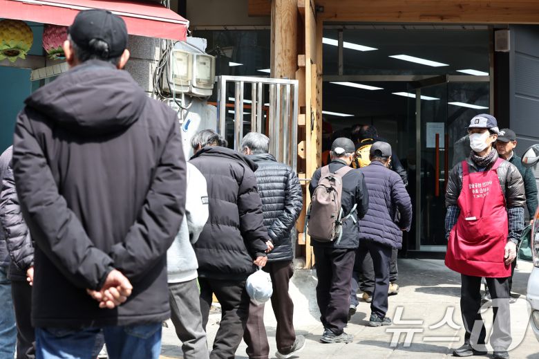 서울 종로구 탑골공원 인근 무료급식소 앞에 어르신들이 길게 줄을 서 식사 차례를 기다리고 있다.  ⓒ News1 민경석 기자
