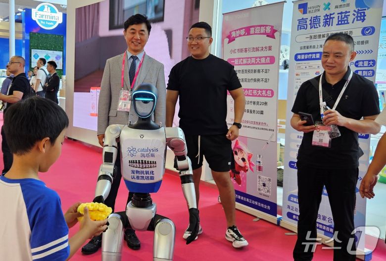 최이돈 원장이 23일 중국 하문에서 열린 WESAVC 전시장에서 인공지능 로봇을 보고 있다. ⓒ 뉴스1