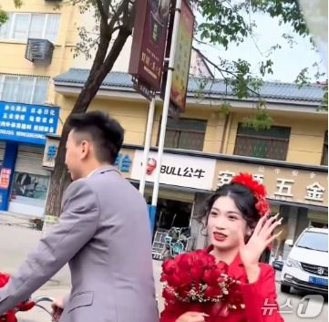 박수를 치는 마을 사람들에게 손을 흔들고 있는 신부. SCMP 갈무리