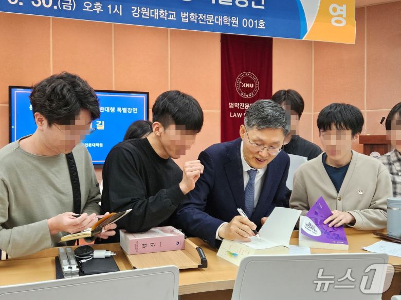 문형배 전 헌법재판소장 권한대행이 30일 오후 강원대학교 법학전문대학원 대강당에서 재학생과 교직원들을 대상으로 '법률가의 길'을 주제로 특별강연을 끝낸 뒤 재학생의 사인 요청에 법전에 사인을 해주고 있다.2025..5.30 한귀섭 기자