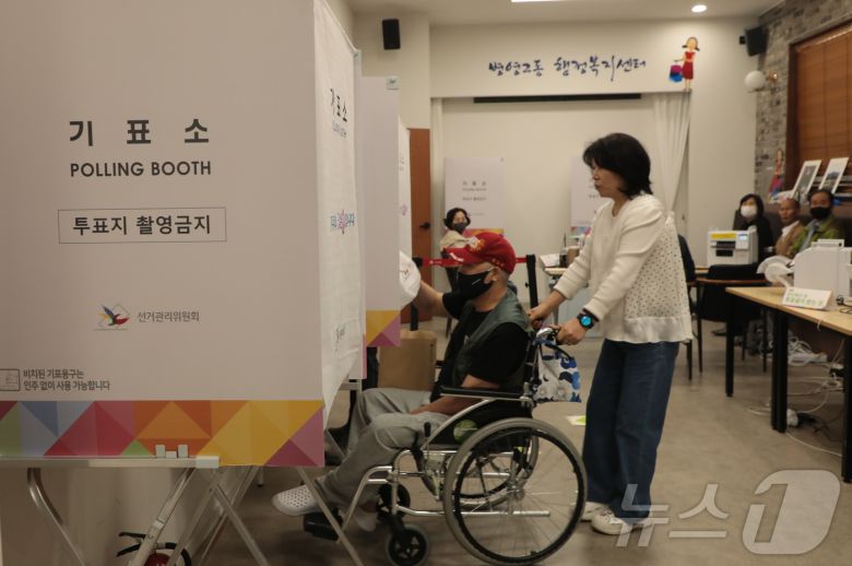 제21대 대통령선거 사전투표 이틀차인 30일 오전 울산 중구 병영2동 행정복지센터에서한 시민이 보조인의 도움을 받아 휠체어를 타고 소중한 한 표를 행사했다. 2025.5.30. ./뉴스1 ⓒ News1 김세은 기자