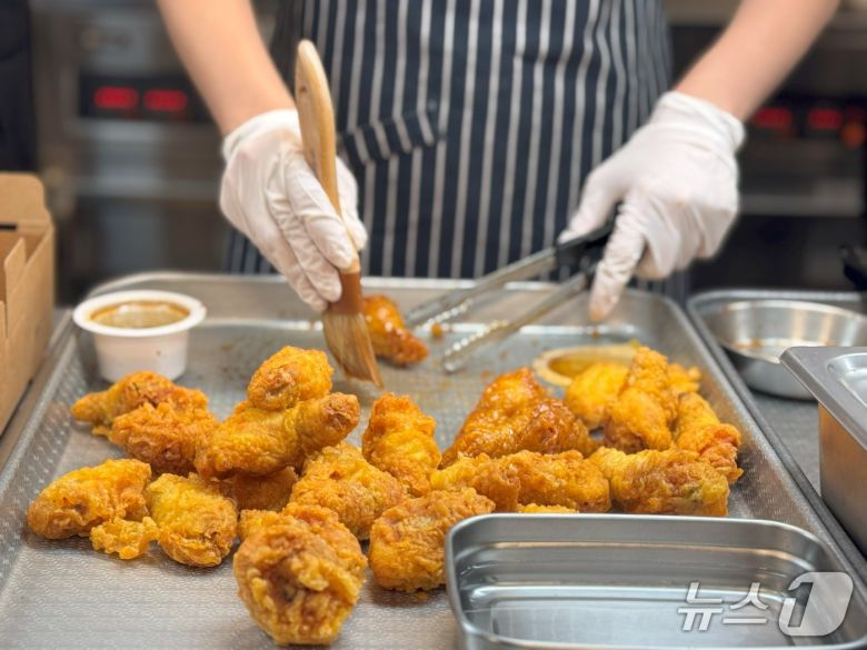 30일 경기도 오산시에 위치한 교촌에프앤비의 R&D센터 '정구관'에서 '교촌 1991스쿨'프로그램을 진행한 가운데 박보라 아띠교육팀 담당이 허니콤보 소스 도포 과정을 시연하고 있다.2025.05.30/뉴스1 ⓒ News1 이강 기자