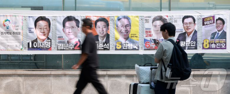 제21대 대통령선거가 이틀 앞으로 다가온 1일 서울 중구 4호선 명동역 앞에서 시민들이 후보자들의 선거 벽보 앞으로 지나고 있다. 2025.6.1/뉴스1 ⓒ News1 김진환 기자