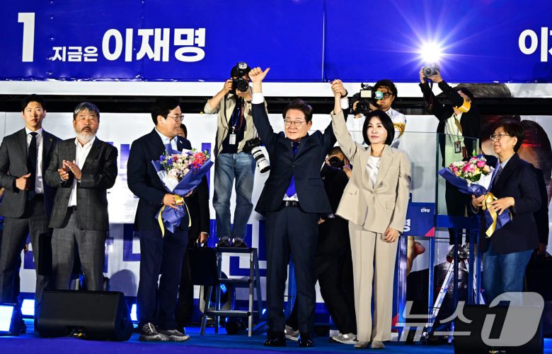 제21대 대통령 선거에서 당선이 확실해진 이재명 더불어민주당 후보가 김혜경 여사와 4일 오전 서울 여의도 국회 앞에 마련된 개표방송 야외 무대에 올라 인사하고 있다. (공동취재) 2025.6.4/뉴스1 ⓒ News1 안은나 기자