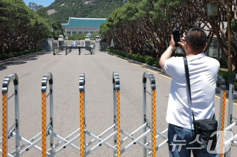 권력의 상징에서 ‘국민 품으로 돌아간 공간’으로 환영받았던 청와대가 다시 대통령 집무실로 변경될 예정인 가운데 4일 휴관으로 문이 닫힌 청와대를 찾은 외국인 관광객이 기념 사진을 찍고 있다. 2025.6.4/뉴스1 ⓒ News1 박정호 기자