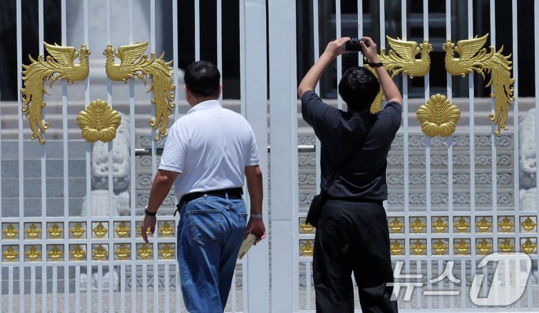 권력의 상징에서 ‘국민 품으로 돌아간 공간’으로 환영받았던 청와대가 다시 대통령 집무실로 변경될 예정인 가운데 4일 휴관으로 문이 닫힌 청와대를 찾은 시민들이 기념 사진을 찍고 있다. 2025.6.4/뉴스1 ⓒ News1 박정호 기자