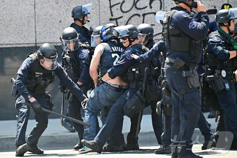 8일(현지시간) 미국 캘리포니아주 로스앤젤레스 시내 메트로폴리탄 구치소 MDC 밖에서 경찰 및 관계자들이 시위대와 충돌하고 있다. ⓒ AFP=뉴스1 ⓒ News1 김성진 기자