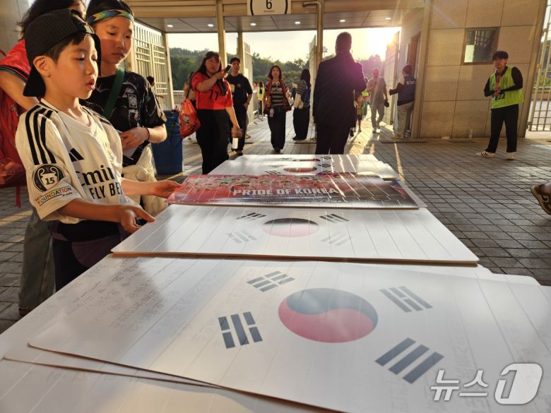 한국-쿠웨이트전에 입장하는 팬들이 태극기 클래퍼를 받아들고 있다. ⓒ News1 안영준 기자