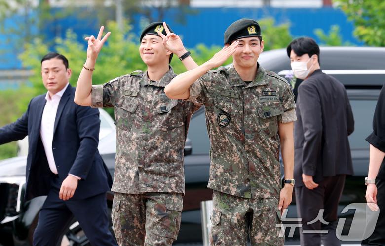 방탄소년단(BTS)의 RM(김남준, 30)과 뷔(김태형, 29)가 10일 오전 강원도 춘천시 신북읍 체육공원 축구장에서 군 복무를 마친 뒤 전역 인사를 하고 있다. ⓒ News1 권현진 기자