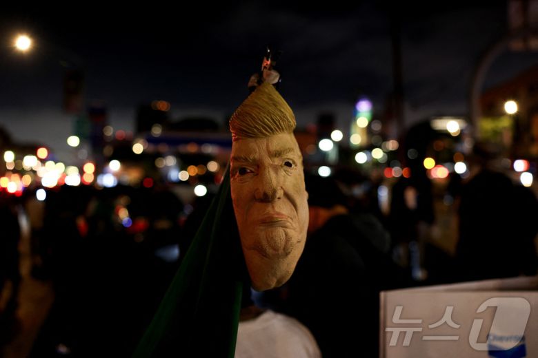 8일(현지시간) 미국 캘리포니아주 로스앤젤레스(LA) 시내에서 열린 연방 이민단속 반대 시위에서 한 시위자가 도널드 트럼프 미국 대통령을 묘사한 가면을 쓰고 있다. 2025.6.8 ⓒ 로이터=뉴스1 ⓒ News1 신기림 기자