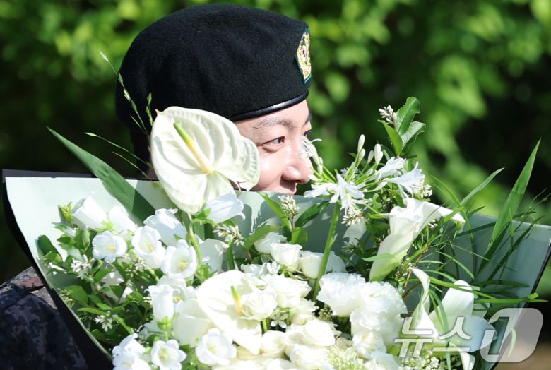 방탄소년단(BTS)의 정국이 11일 오전 경기도 연천군 연천공설운동장에서 군 복무를 마친 뒤 꽃다발을 받고 수줍은 미소를 짓고 있다. 정국과 지민은 지난 2023년 12월 입대해 경기도 연천에 위치한 육군 제5보병사단에서 약 1년 7개월간 병역의 의무를 성실히 수행했다. 2025.6.11/뉴스1 ⓒ News1 권현진 기자