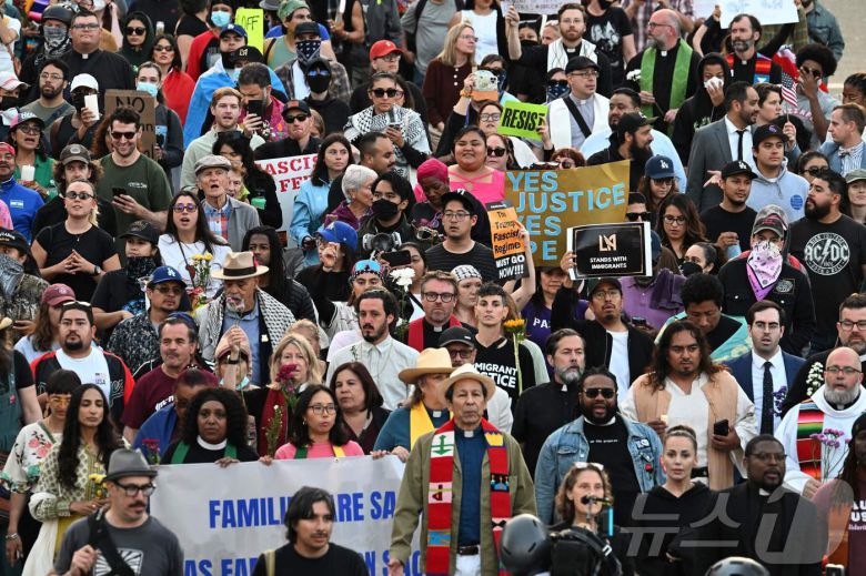 2025년 6월 10일 연방 이민단속 작전에 반대하는 시위가 계속되는 가운데 기도회에 참석한 사람들이 로스앤젤레스 시내의 연방 건물로 걸어가고 있다. ⓒ AFP=뉴스1 ⓒ News1 신기림 기자