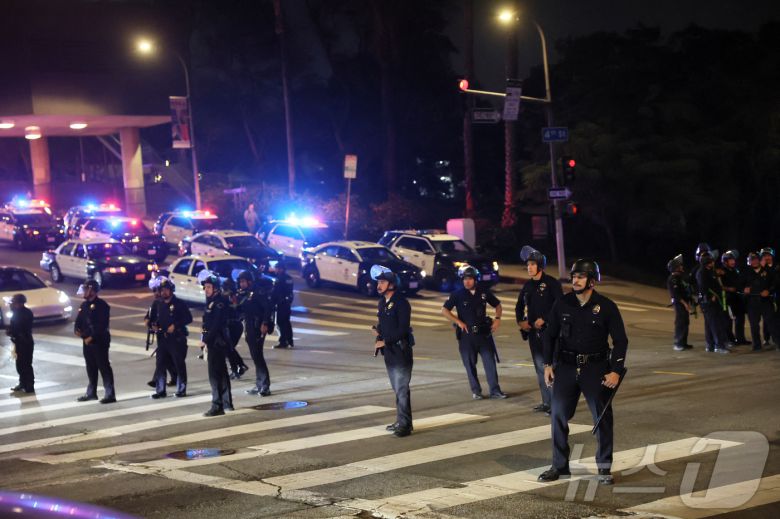 미국 캘리포니아주 로스앤젤레스(LA) 시내에서 이민 단속 작전에 반대하는 시위로 인해 야간 통행금지령이 선포되자 법 집행관들이 경비를 서고 있다. 2025.6.10 ⓒ 로이터=뉴스1 ⓒ News1 김경민 기자