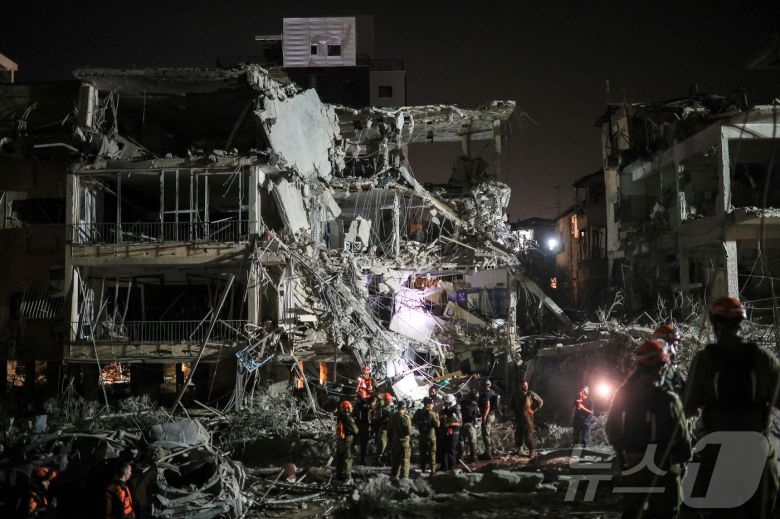 13일(현지시간) 이란의 미사일 반격으로 파괴된 이스라엘 라맛간의 건물 잔해에서 요원들이 구조 작업 활동을 벌이고 있다. 2025.06.13 ⓒ 로이터=뉴스1 ⓒ News1 류정민 특파원