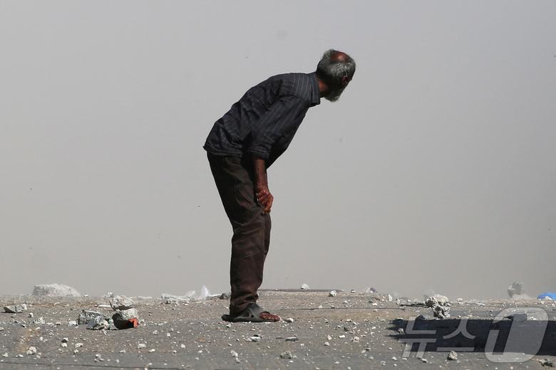 15일(현지시간) 가자지구 중부 팔레스타인 난민촌에서 이스라엘의 공습으로 부상당한 팔레스타인 남성이 이동하고 있다. ⓒ AFP=뉴스1