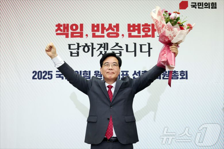 송언석 국민의힘 신임 원내대표가 16일 오후 서울 여의도 국회에서 열린 2025 국민의힘 원내대표 선출 의원총회에서 꽃다발을 든 채 손을 들어올리고 있다. (공동취재) 2025.6.16/뉴스1 ⓒ News1 이재명 기자