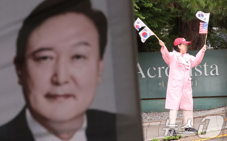 25일 서울 서초구 아크로비스타 윤석열 전 대통령 사저 앞에서 한 지지자가 태극기를 흔들고 있다.  2025.6.25/뉴스1 ⓒ News1 김성진 기자