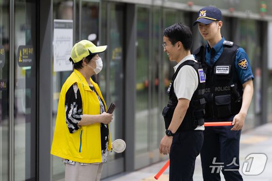 신창훈 지하철경찰대 안전계장이 2일 서울 성동구 왕십리역 승강장을 순찰하다 장애인 안내도우미와 대화하고 있다. 2025.7.2  ⓒ 뉴스1 이승배 기자