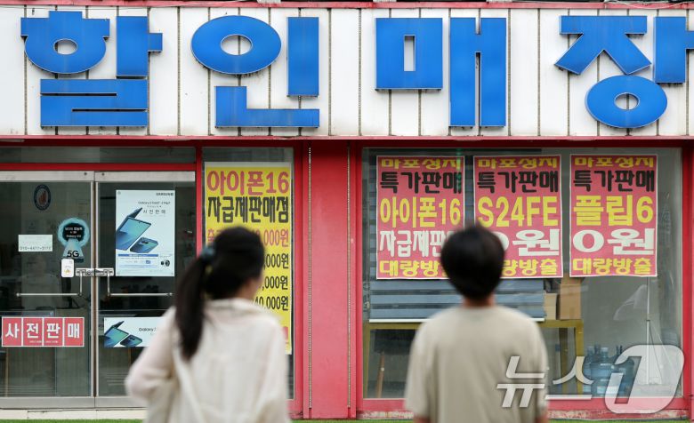 서울 시내 한 핸드폰 매장앞에서 시민들이 이동하고 있다. 2025.7.20/뉴스1 ⓒ News1 황기선 기자
