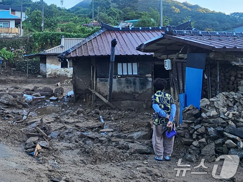 22일 경남 산청군 율현마을 산사태 실종자의 아내 전인호 씨(74)가 자신의 집과 주변을 살펴보며 실종된 남편을 찾고 있다. 2025.7.22/뉴스1 ⓒ News1 한송학 기자