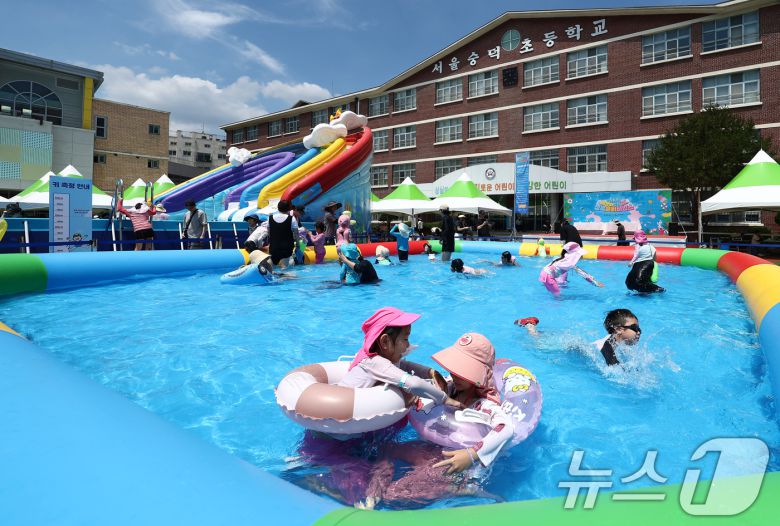 전국에 무더운 더위가 이어지는 26일 서울 성북구 숭덕초등학교에 마련된 성북문화바캉스 물놀이장에서 가족들이 즐거운 시간을 보내고 있다. ⓒ News1 김민지 기자