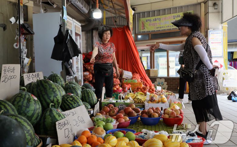 전 국민에게 1인당 15만~45만원을 지급하는 '민생회복 소비쿠폰' 지급 첫 주말인 26일 광주 서구 양동시장에서 한 손님이 과일을 고르고 있다. 2025.7.26/뉴스1 ⓒ News1 이수민 기자